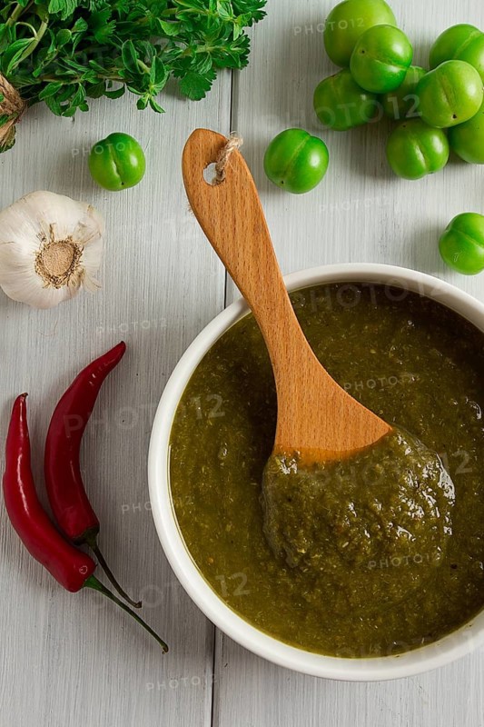 Tkemali sauce, traditional Georgian cuisine, green cherry plum, with ingredients for sauce, cilantro, mint, hot pepper, garlic, on a white wooden table, close-up, rustic, food background, no people, selective focus, sauce, green sauce, tkemali, georgian cuisine, homemade