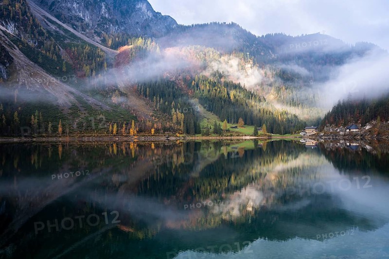 The Vordere Gosausee in autumn with a view of the Gasthof Gosausee. Sun and clouds. Overcast. Reflection. Vorderer Gosausee, Gosau, Gosau Valley, Salzkammergut, Upper Austria, Austria, Europe