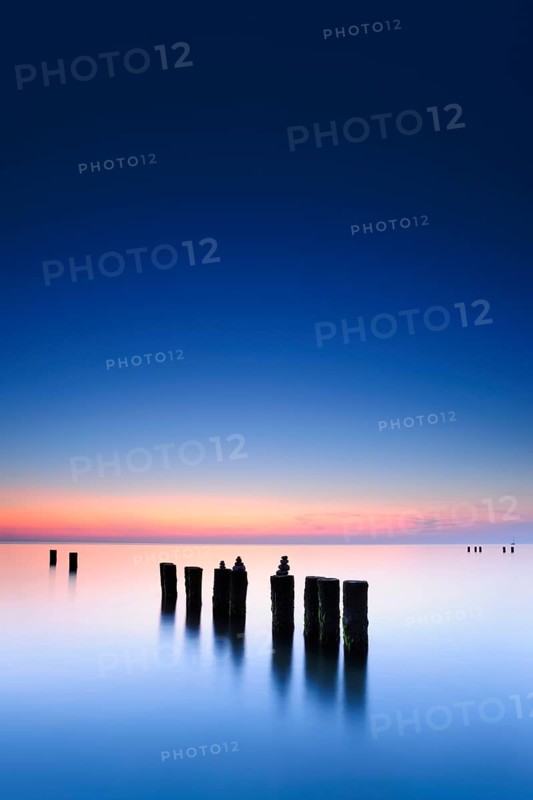 Stone pyramids on old groynes with algae in the water on the beach of the Baltic Sea, long exposure at sunset, Wustrow, Fischland-Darß-Zingst peninsula, Mecklenburg-Vorpommern, Germany, Europe