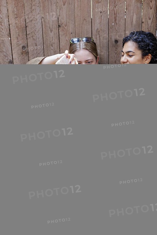 Young woman giving a lamb a bottle of milk in her arms, North Sea island of Borkum, 18.05.2024. Rearing lambs, lamb