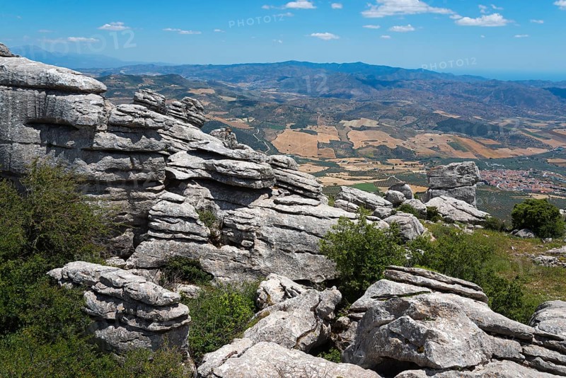 Huge rock formations in front of a wide landscape with fields and mountain ranges under a clear sky, Karst Mountains, Torcal Alto, El Torcal de Antequera, Sierra del Torcal, Malaga, Andalusia, Spain, Europe
