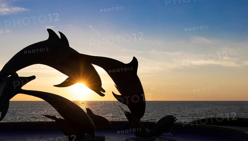Dolphine silhouettes at Mazatlan sea promenade, El Malecon, with ocean lookouts, tourist beaches and scenic landscapes. It connects Old Mazatlan with Hotel Zone Zona Hotelera