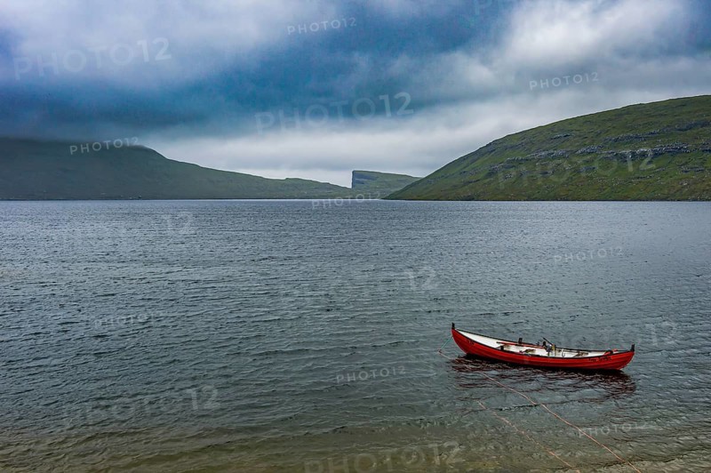 Little red boat in a lake in Vagar, Faroe islands, Denmark, Europe