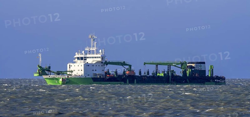 DEME trailing suction hopper dredger Uilenspiegel at sea, used for sand replenishment, beach nourishment to make wider beaches to reduce storm damage