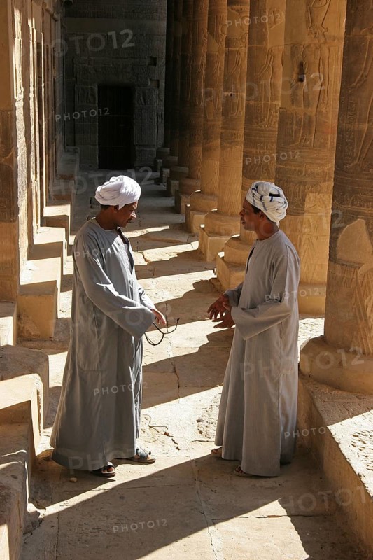 Two Egyptian men carrying jalabiyas at the Philae Temple of Isis on Agilkia Island in Lake Nasser, Aswan, Egypt, North Africa, Africa