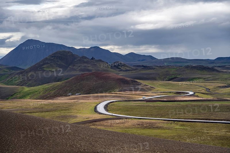 Road through volcanic landscape with colourful hills, Krafla geothermal area, Northern Iceland, Iceland, Europe