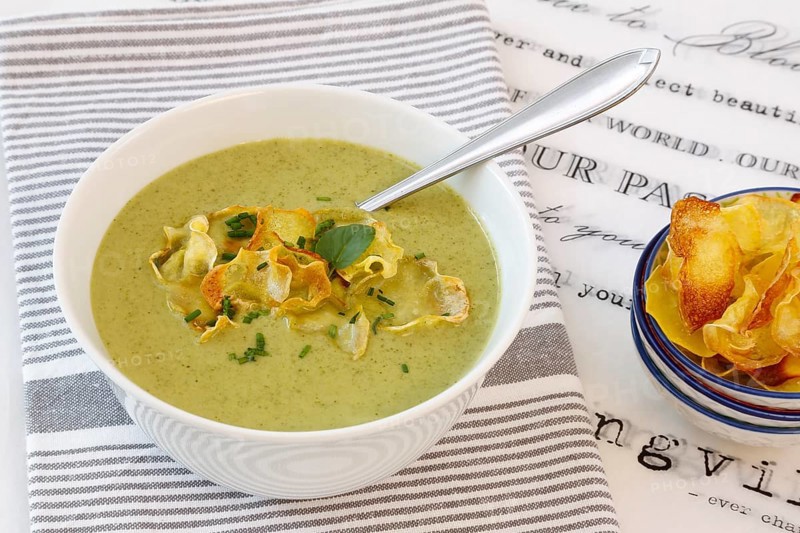 Swabian cuisine, cress soup with crisps, cress, plate with green cream soup, soup bowl, garnished with herbs, hearty soup, bowl with crisps, tea towel, writing, letters, vegetarian, healthy, salty, cooking, typical Swabian reinterpreted, traditional cuisine, food photography, studio, tablecloth, Germany, Europe