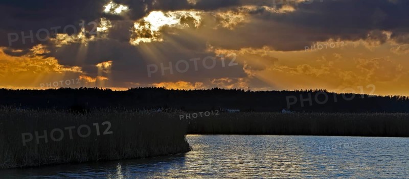 Sunbeams through the clouds at sunset on the Trebel River, Peene Valley River Landscape nature park Park, Mecklenburg-Western Pomerania, Germany, Europe