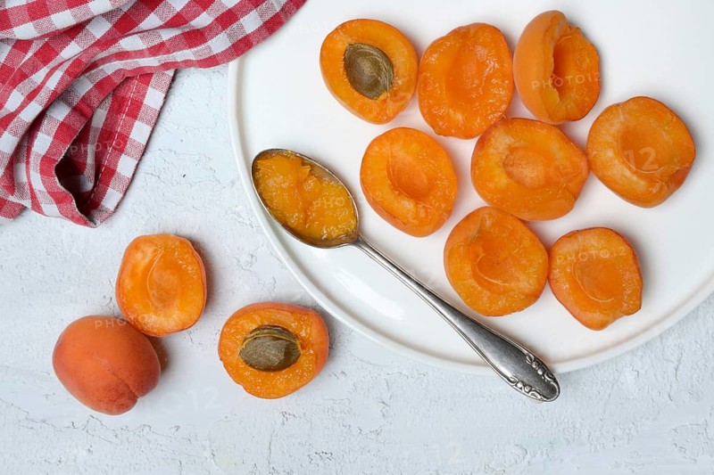 Apricot, apricot halves on plate with spoon
