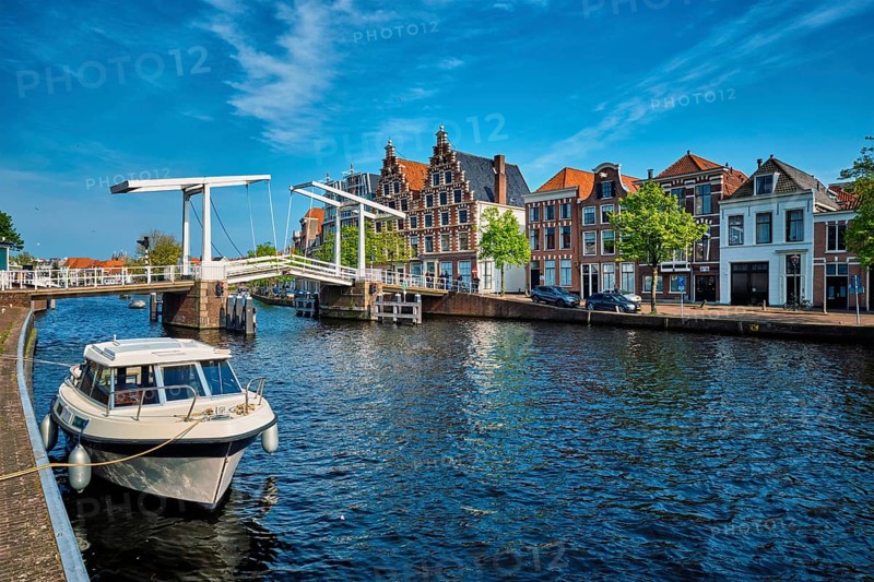 Spaarne river with boat and Gravestenenbrug bridge famous tourist landmark in Haarlem, Netherlands