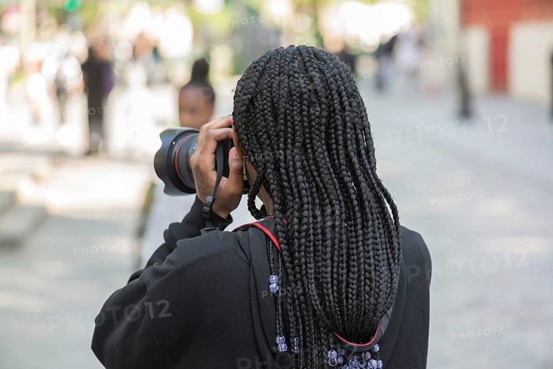 Young girl with black dreadlocks taking a photo, Paris, France, Europe