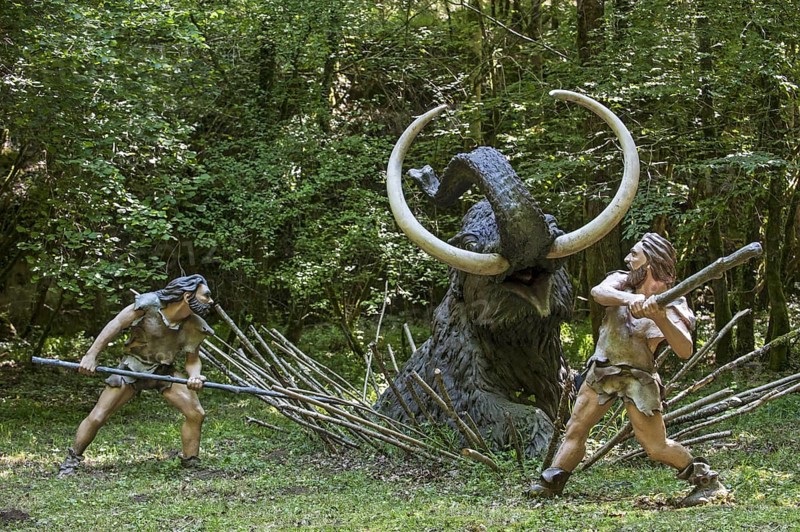 Diorama showing Neanderthal hunters killing trapped prehistoric mammoth at Prehisto Parc, theme park about prehistoric life at Tursac, Périgord, Dordogne, France, Europe