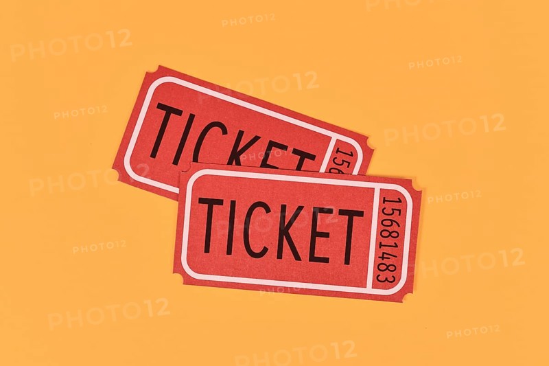 Two old fashioned red tickets on yellow background