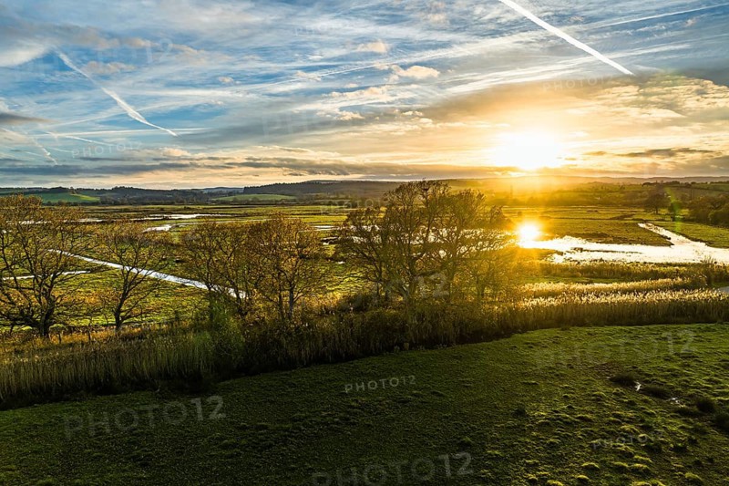 Sunset over Wetlands and Marshes in RSPB Exminster and Powderham Marshe from a drone, Exeter, Devon, England, United Kingdom, Europe