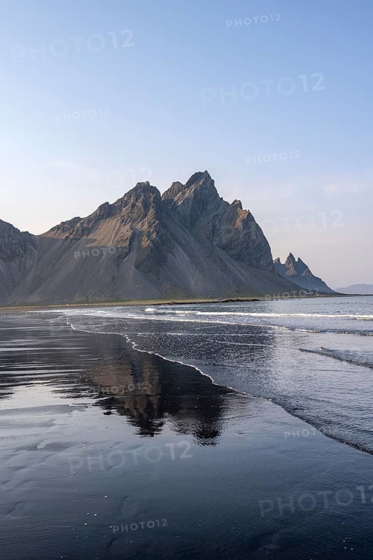 Black lava beach, sandy beach and sea, mountains Klifatindur reflected in the water, Eystrahorn and Kambhorn, headland Stokksnes, mountain range Klifatindur, Austurland, East Iceland, Iceland, Europe