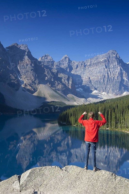 Tourist with open arms on look-out point looking over Moraine Lake in the Valley of the Ten Peaks, Banff National Park, Alberta, Canada | MR:yes Arndt Kobbe