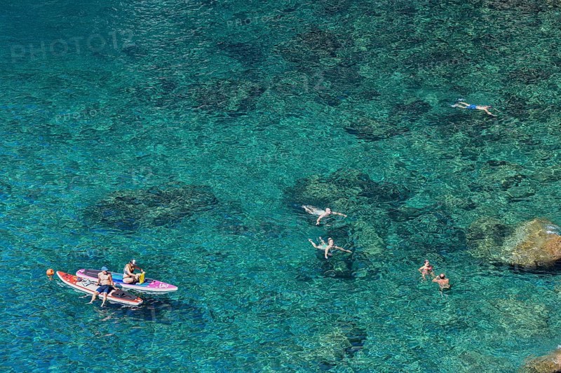 Bathers in the rocky bay of Corniglia, Cinque Terre, province of La Spezia, Liguria, Italy, Europe