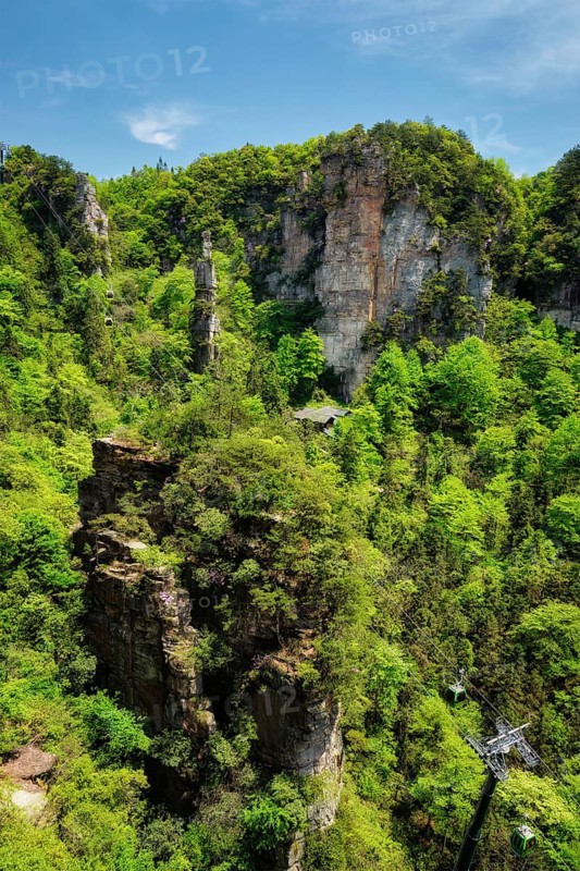 Famous tourist attraction of China, Zhangjiajie stone pillars cliff mountains with cable railway car lift at Wulingyuan, Hunan, China. With camera pan