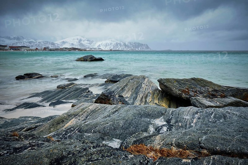 Waves of Norwegian sea on rocky beach of fjord. Ramberg beach, Lofoten islands, Norway, Europe