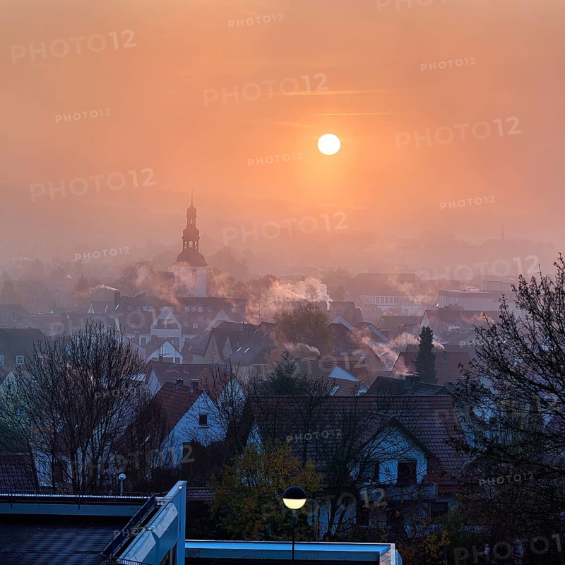 View of the town from above, houses and church tower in autumn, sunrise in the fog, smoky chimneys, backlight, Beverungen, Höxter, Weserbergland, North Rhine-Westphalia, Germany, Europe