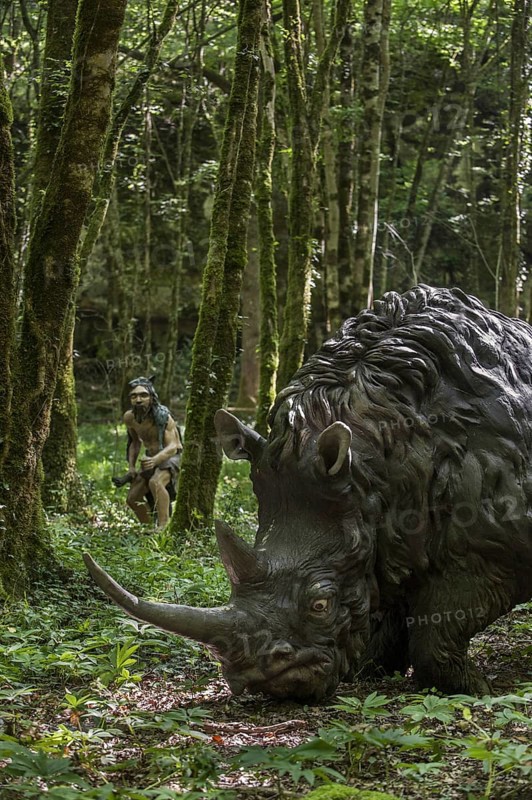 Diorama showing Neanderthal hunter chasing woolly rhinoceros (Coelodonta antiquitatis) at Prehisto Parc, theme park about prehistoric life at Tursac, Périgord, Dordogne, France, Europe
