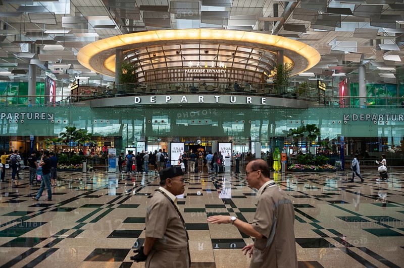01.03.2019, Singapore, Republic of Singapore, Asia, Two airport employees talk in the departure hall of Terminal 3 at Changi Airport, Asia