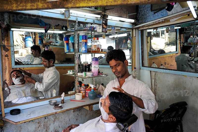 08.12.2011, Mumbai, Maharashtra, India, Asia, A barber shaves a customer in a small men's parlour in the Dharavi slum of Mumbai, Asia