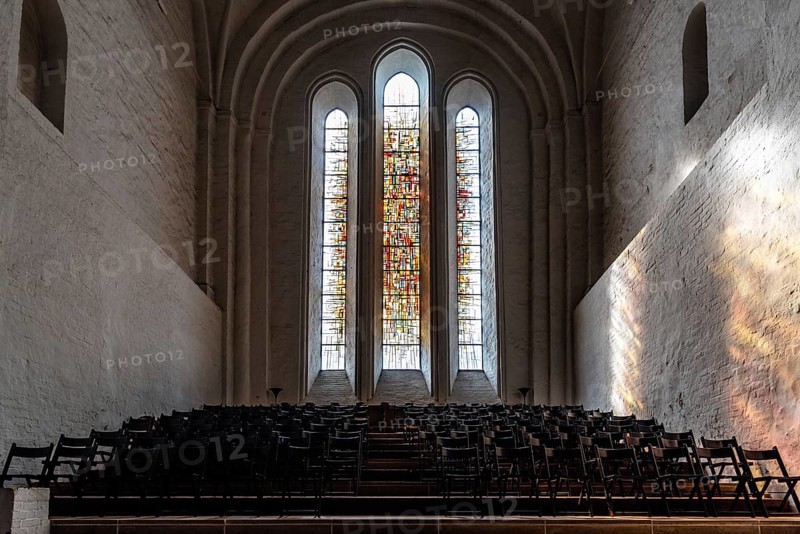 Lubeck, Germany, August 3, 2019: Stained glass window and chairs in the interior of the Cathedral, Europe