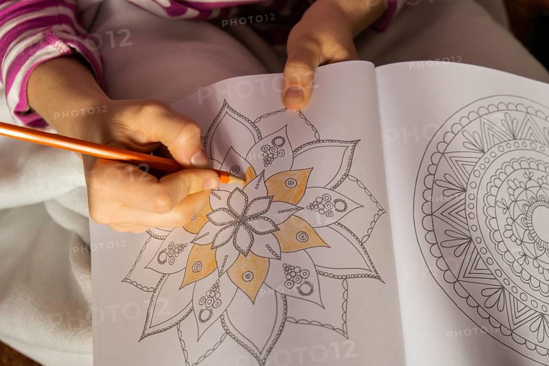 Woman coloring antistress page. Female hand painting mandala. Female painting mandalas to combat stress. Relaxing hobby mental wellbeing and art therapy. Woman paints sketch, meditative process of coloring pages. Self expression by art