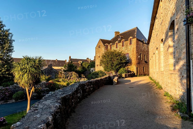 Picturesque narrow street of the medieval village of Locronan a sunny day of summer at evening