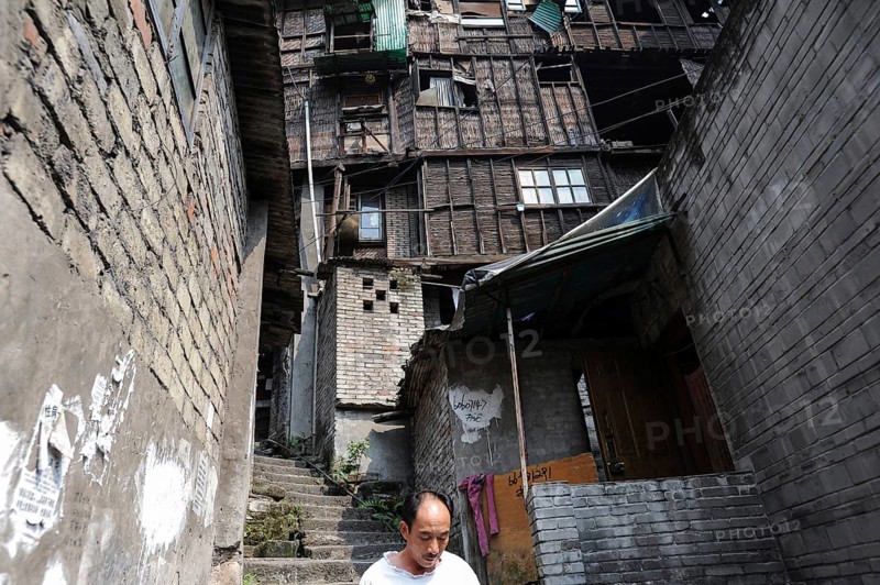 04/08/2012, Chongqing, China, Asia, A man in the Eighteen Stairs area with traditional houses in the old town of the Shibati area in Yuzhong district. The government has started to demolish many traditional old houses in the Shibati area and turn it into a place that attracts tourists. The Chinese megacity of Chongqing is located at the confluence of two major waterways, the Yangtze River and the Jialing River, and is one of the fastest growing metropolises in the world. Chongqing is also one of China's five city-states, with the city of Chongqing being the most densely populated urban region in China, Asia