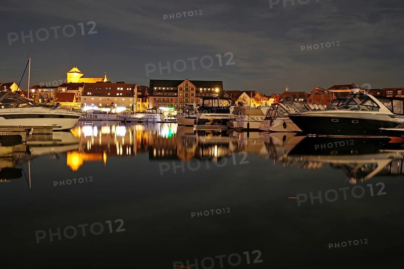 Boats in the harbour at night, illuminated cityscape reflected, Waren, Müritz, Mecklenburg-Vorpommern, Germany, Europe