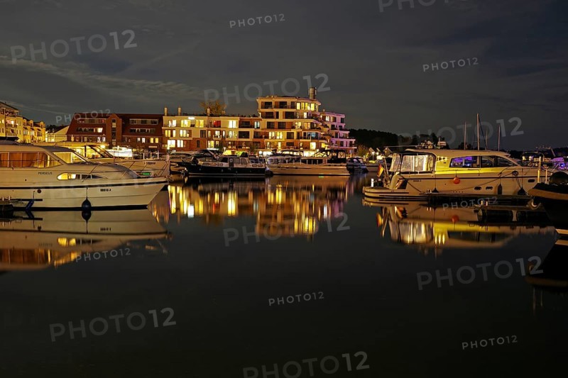 Marina at night with illuminated buildings and reflection in the water, Waren, Müritz, Mecklenburg-Vorpommern, Germany, Europe