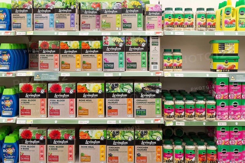 Shelves with boxes of Levington and other fertiliser products, Notcutts garden centre, Woodbridge, Suffolk, England, UK