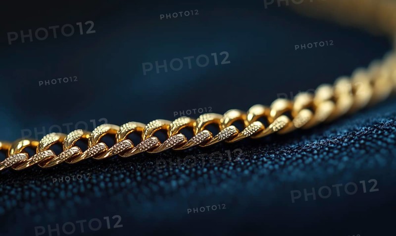 A gold chain with a diamond shaped clasp. The chain is on a dark blue surface AI generated