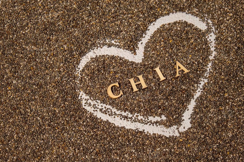 Heart made of chia seeds with word CHIA inside background. Healthy superfood rich in Omega 3 fatty acids. Dry healthy natural ingredient. Vegetarian food favorite dietary products