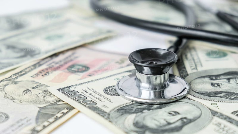 Stack of cash dollars and stethoscope. The concept of medical expensive medicine, doctors salary. Copy space for text. Health Life insurance. vaccination costs. Financial crisis. Covid-19 crimes