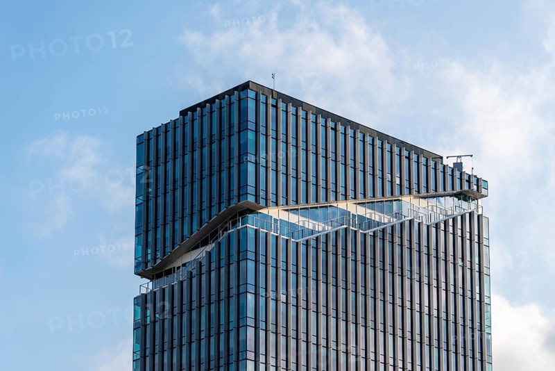 Amsterdam, Netherlands, May 7, 2022: Low angle view of futuristic architecture skyscraper against sky. Contemporary architecture, blue colors. Low angle view