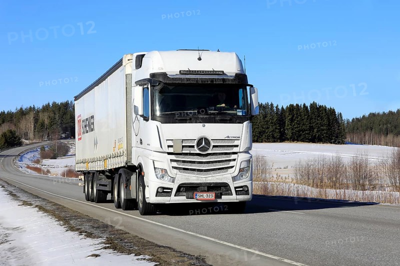 White Mercedes-Benz Actros 2653 truck pulls DB Schenker semi trailer along highway on a sunny day of early spring. Salo, Finland. March 9, 2023