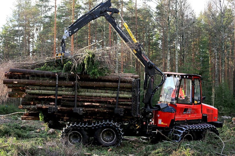 SALO, FINLAND, NOVEMBER 19, 2016: Unnamed operator stacks up wood on the bunk of Komatsu 845 forestry forwarder in forest