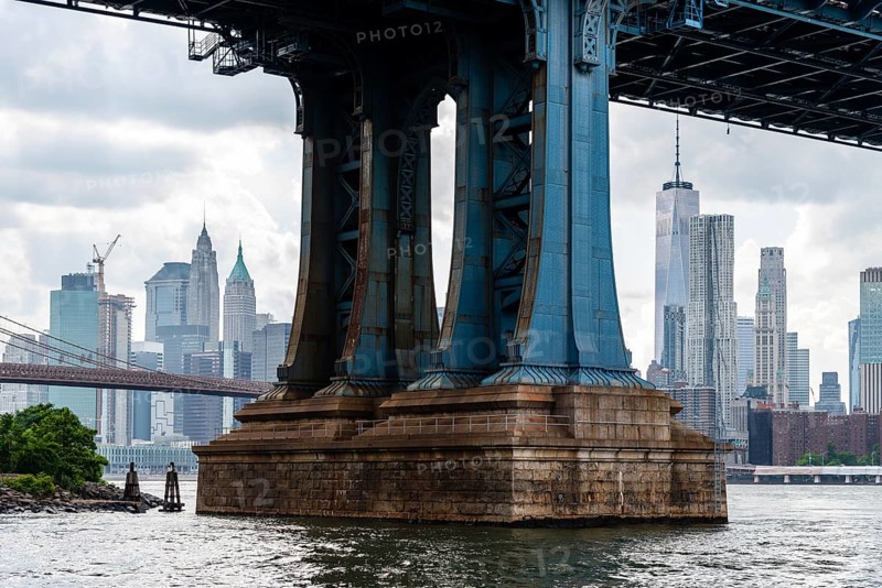Detail of Pillar of Manhattan Bridge against cityscape of New York City. Steel Abutment With Bolt and Rivet Connections. Engineering and architecture