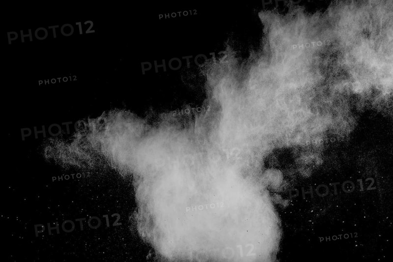 Freeze motion of white dust particles on black background. White powder explosion
