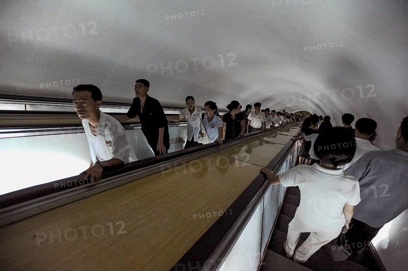 09.08.2012, Pyongyang, North Korea, Asia, Commuters on an escalator leading to an underground station in Pyongyang that is accessible to Western visitors. Some of the escalators go more than one hundred metres underground and serve as bunkers in the event of war, Asia