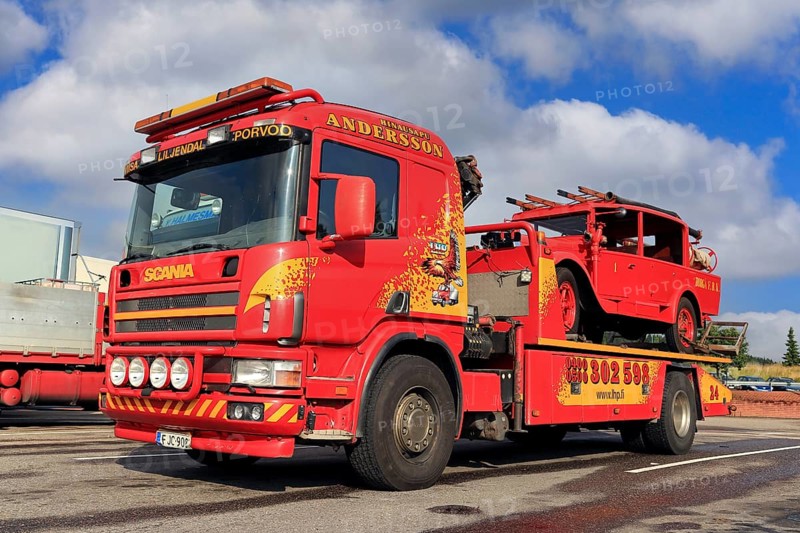 Scania flatbed tow truck of Hinaus Andersson Oy carrying a vintage fire truck. Salo, Finland. August 6, 2015