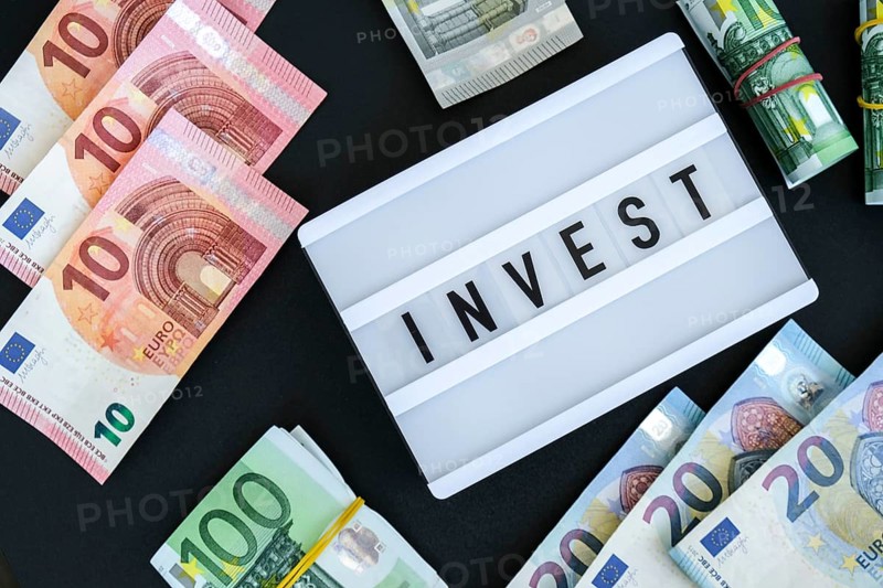 Lightbox board with word INVEST in black letters around euro banknotes. Money, Business, finance, investment, saving. Cash bill. Business budget of wealth and prosperity finance. Passive income