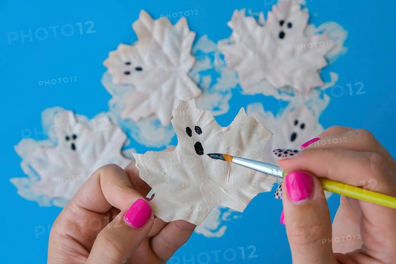 Maple leaf with painted face as decoration for autumn Halloween holiday celebration. Halloween party in October. Holiday Diy preparation. Step by Step Mysterious Jack head lantern