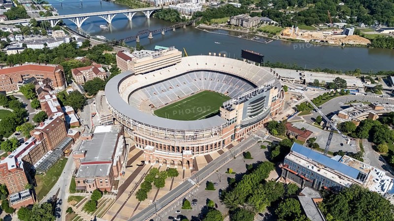 An aerial view of Neyland Stadium reveals a massive, iconic structure nestled by the Tennessee River, with its distinctive bowl shape and seating for over 100, 000 fans, showcasing its rich football heritage
