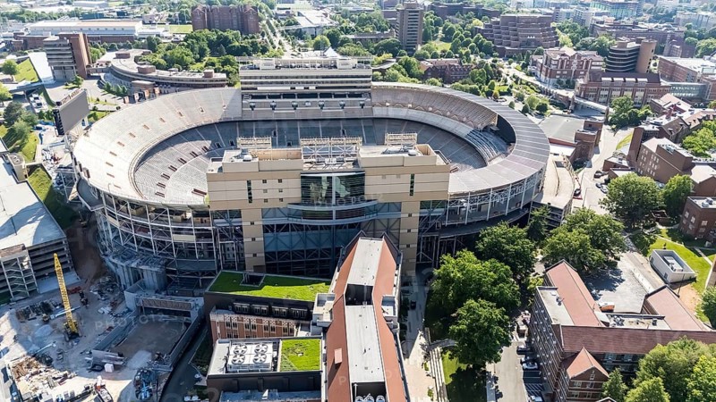 An aerial view of Neyland Stadium reveals a massive, iconic structure nestled by the Tennessee River, with its distinctive bowl shape and seating for over 100, 000 fans, showcasing its rich football heritage