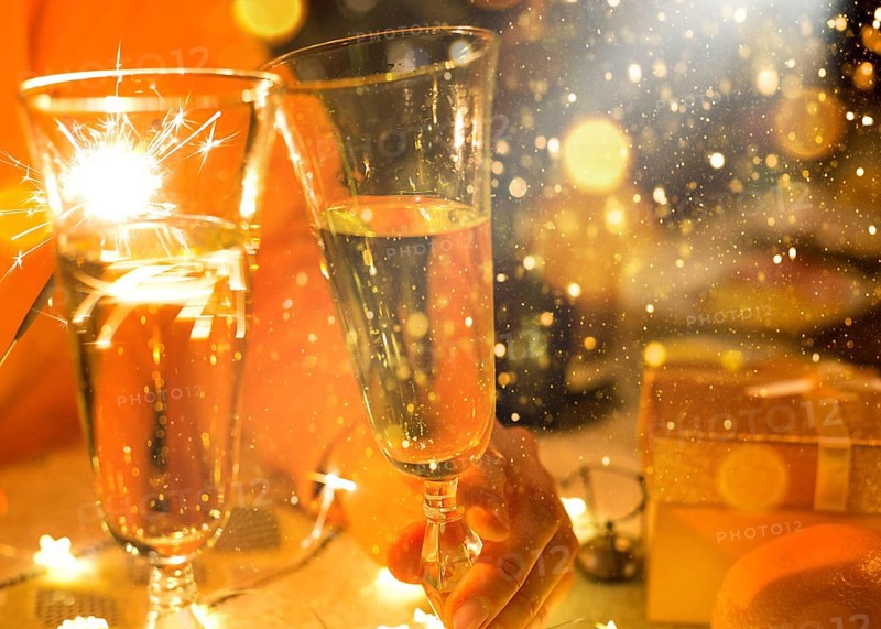Sparklers in a glass of champagne, transparent glass with wine and splashes. New Year, festive mood, celebration. Christmas