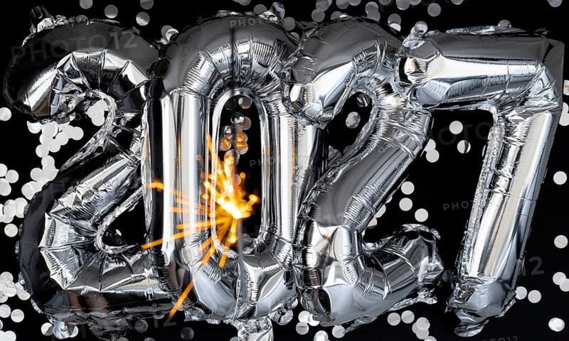 Happy new year 2027 metallic balloons with confetti and sparkler firework Bengal lights on dark black background. Greeting card silver foil balloons numbers Christmas holiday concept. Celebration party congratulation decoration